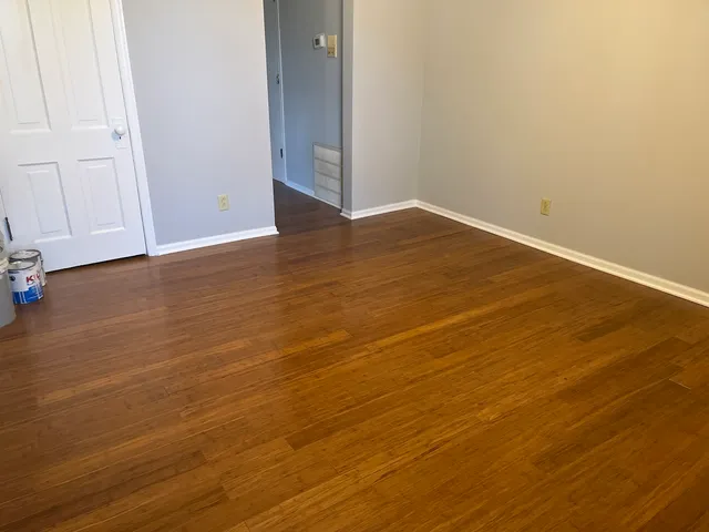a view of an empty room with wooden floor