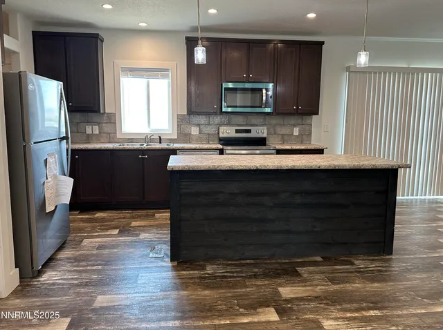 a kitchen with stainless steel appliances granite countertop a stove a sink and a refrigerator