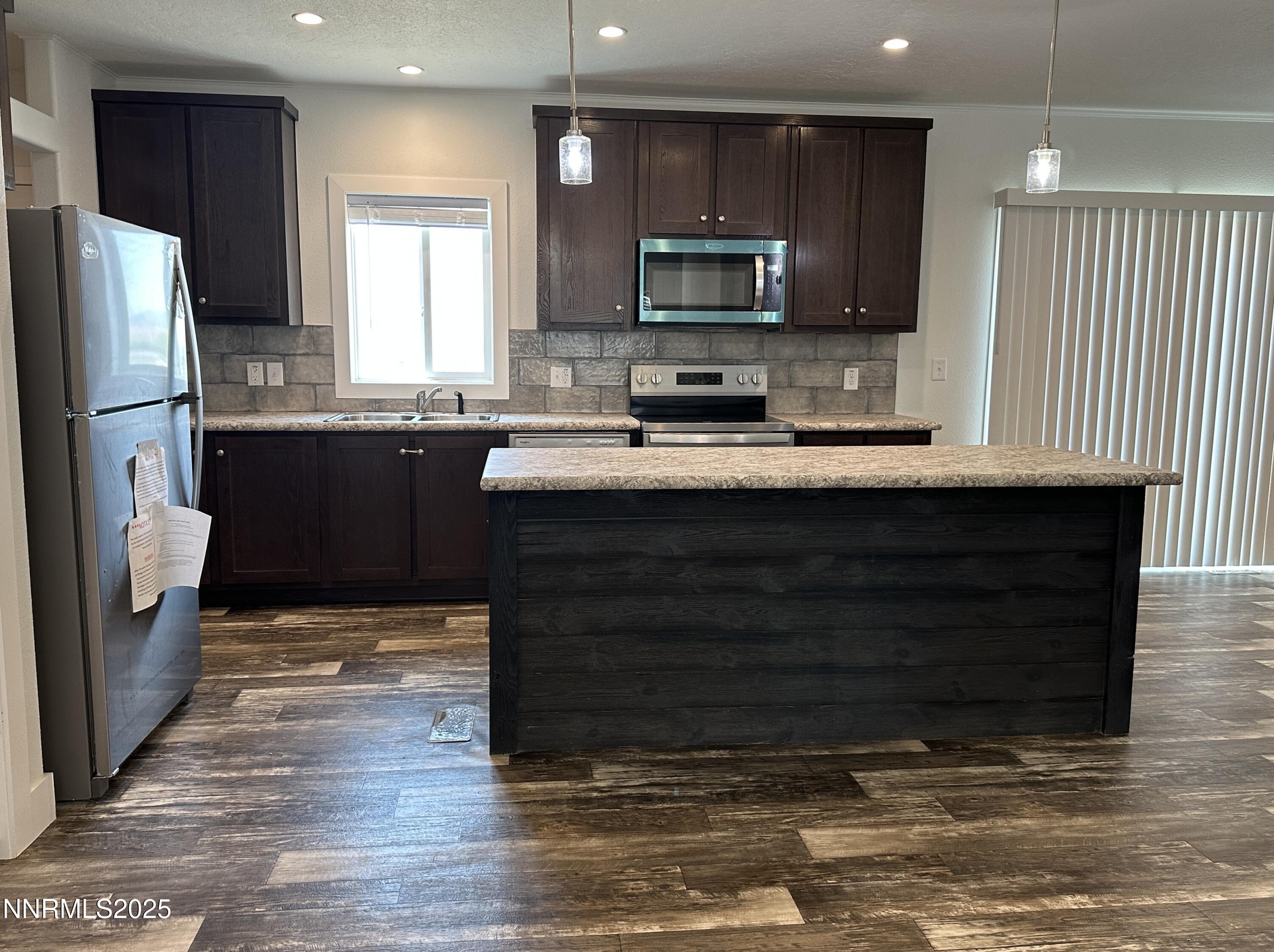 7650 Sylvia Ridge Winnemucca, NV 89445 - Photo 2 of 16 a kitchen with stainless steel appliances granite countertop a stove a sink and a refrigerator