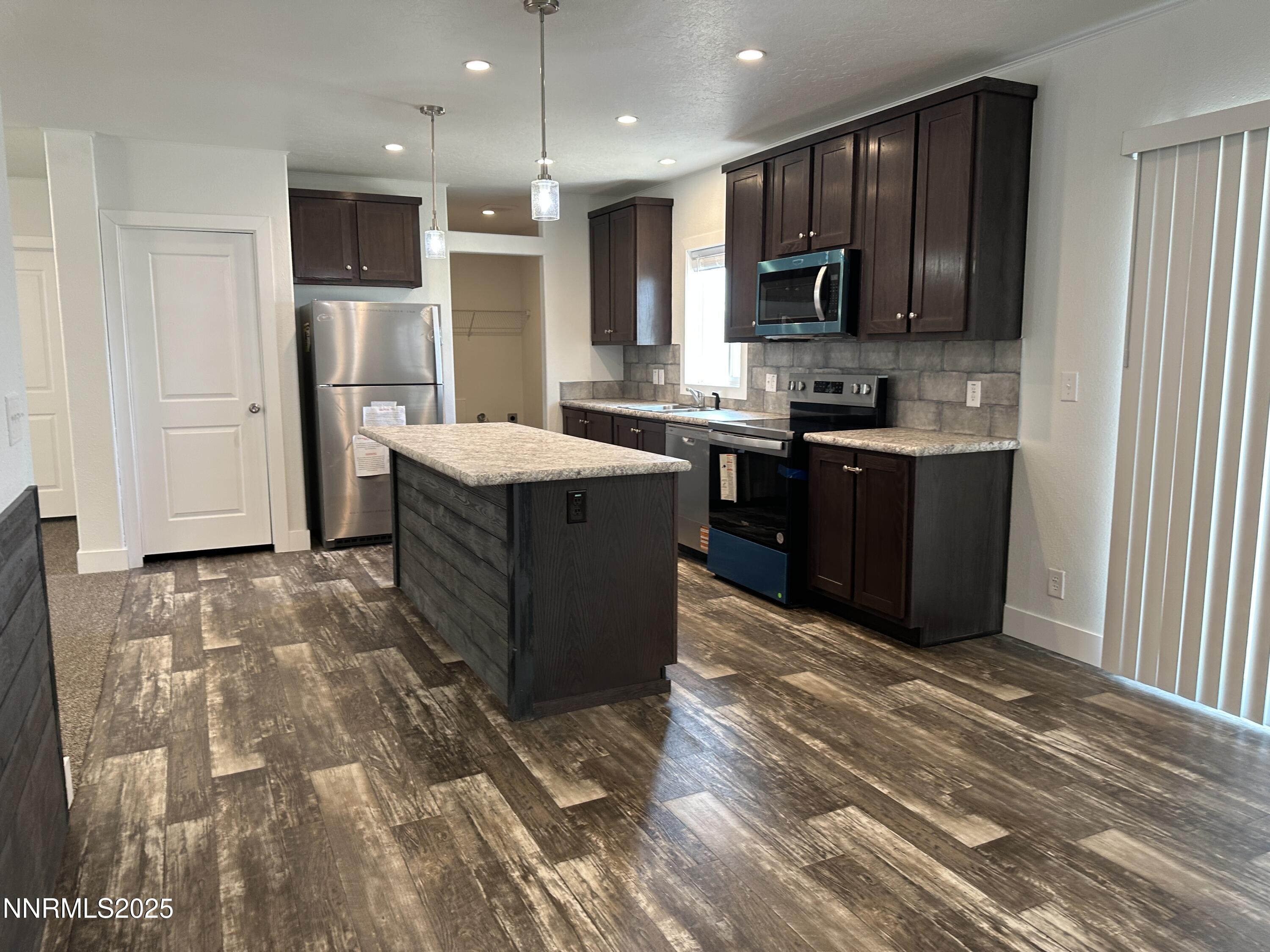 7650 Sylvia Ridge Winnemucca, NV 89445 - Photo 4 of 16 a kitchen with stainless steel appliances granite countertop a stove top oven a sink and a refrigerator