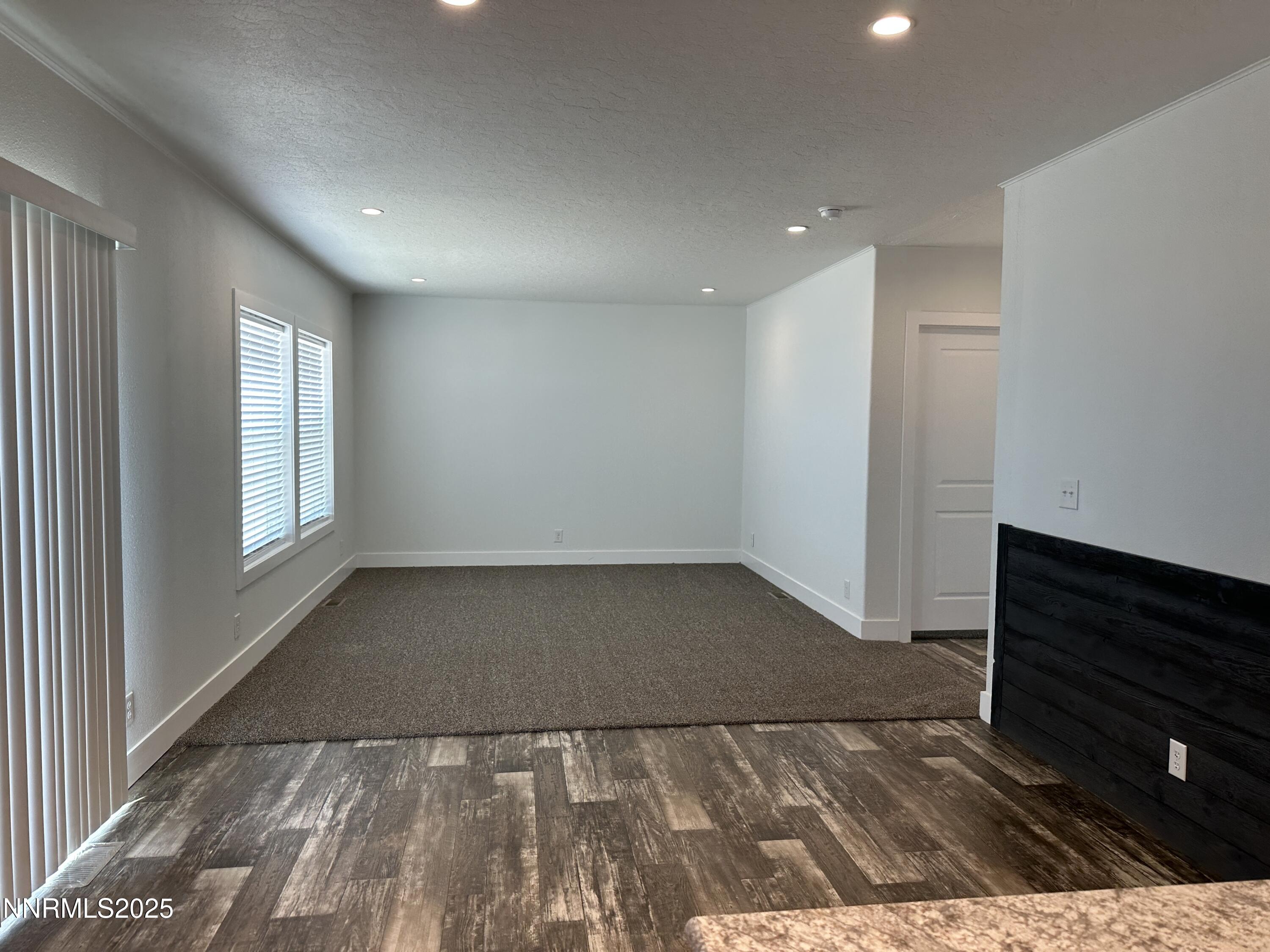 7650 Sylvia Ridge Winnemucca, NV 89445 - Photo 5 of 16 an empty room with wooden floor and windows