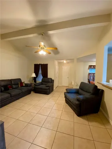 a living room with couches and kitchen view with wooden floor