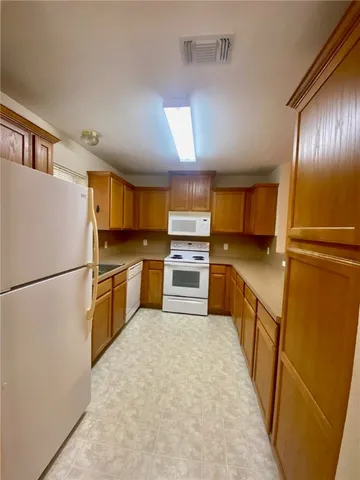 a kitchen with a refrigerator sink stove and cabinets