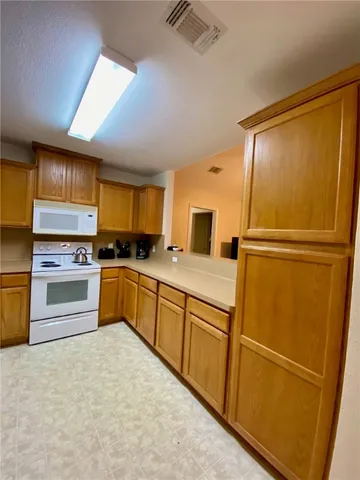 a kitchen with white cabinets and white appliances