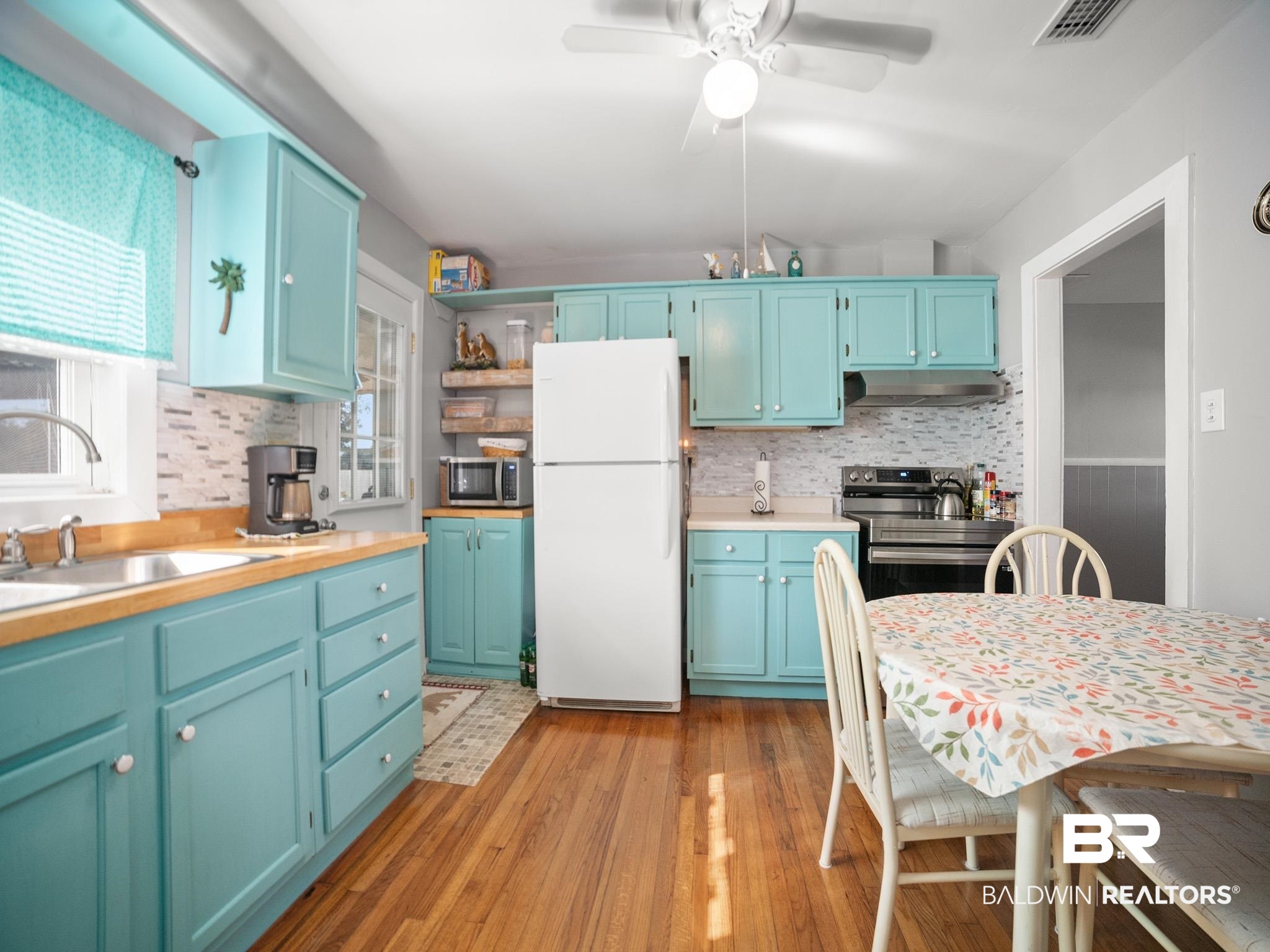 18744 Fairground Road Robertsdale, AL 36567 - Photo 6 of 20 Kitchen featuring blue cabinetry, tasteful backsplash, stainless steel appliances, and light wood-type flooring