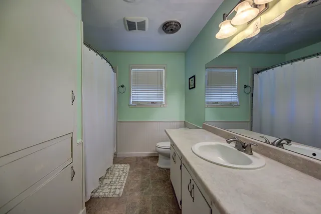 a bathroom with a sink a toilet and mirror
