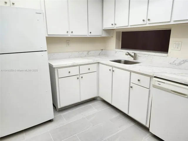 a kitchen with white cabinets and white appliances