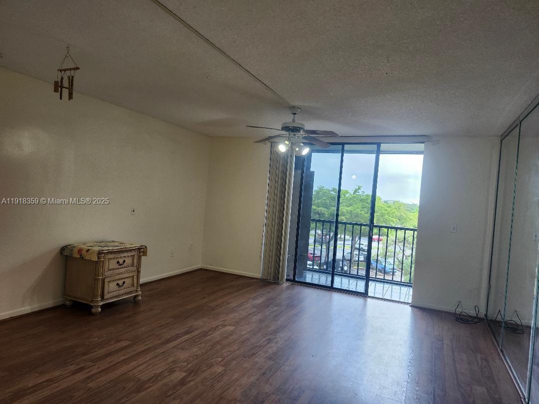 8520 Southwest 133rd Avenue Road, Unit 415 Miami, FL 33183 - Photo 4 of 12 an empty room with wooden floor and windows