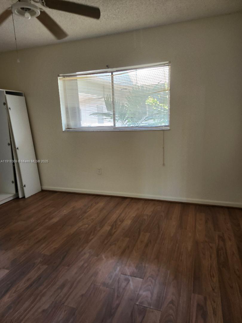 8520 Southwest 133rd Avenue Road, Unit 415 Miami, FL 33183 - Photo 7 of 12 an empty room with wooden floor and windows