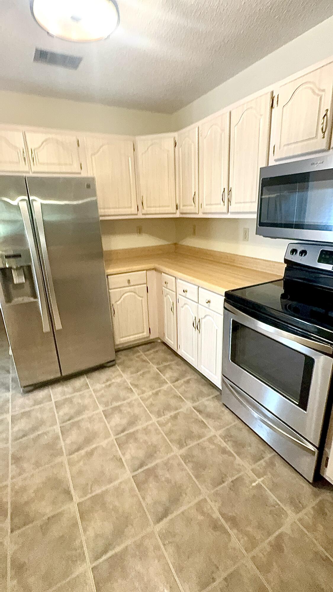 5957 Ridgecrest Road Crestview, FL 32539 - Photo 23 of 56 a kitchen with granite countertop a stove a sink and a refrigerator