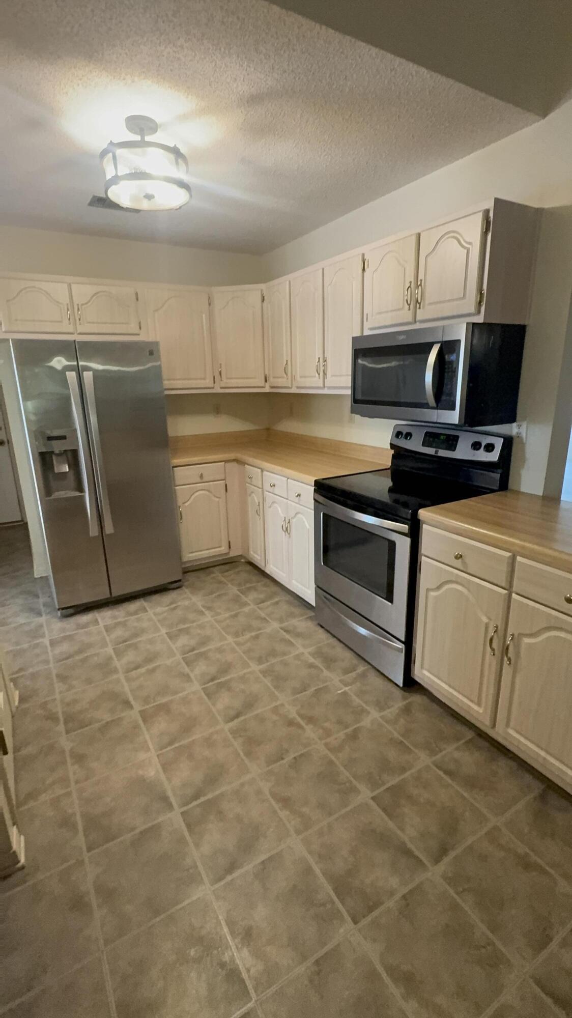 5957 Ridgecrest Road Crestview, FL 32539 - Photo 24 of 56 a kitchen with stainless steel appliances granite countertop a sink a stove top oven and white cabinets
