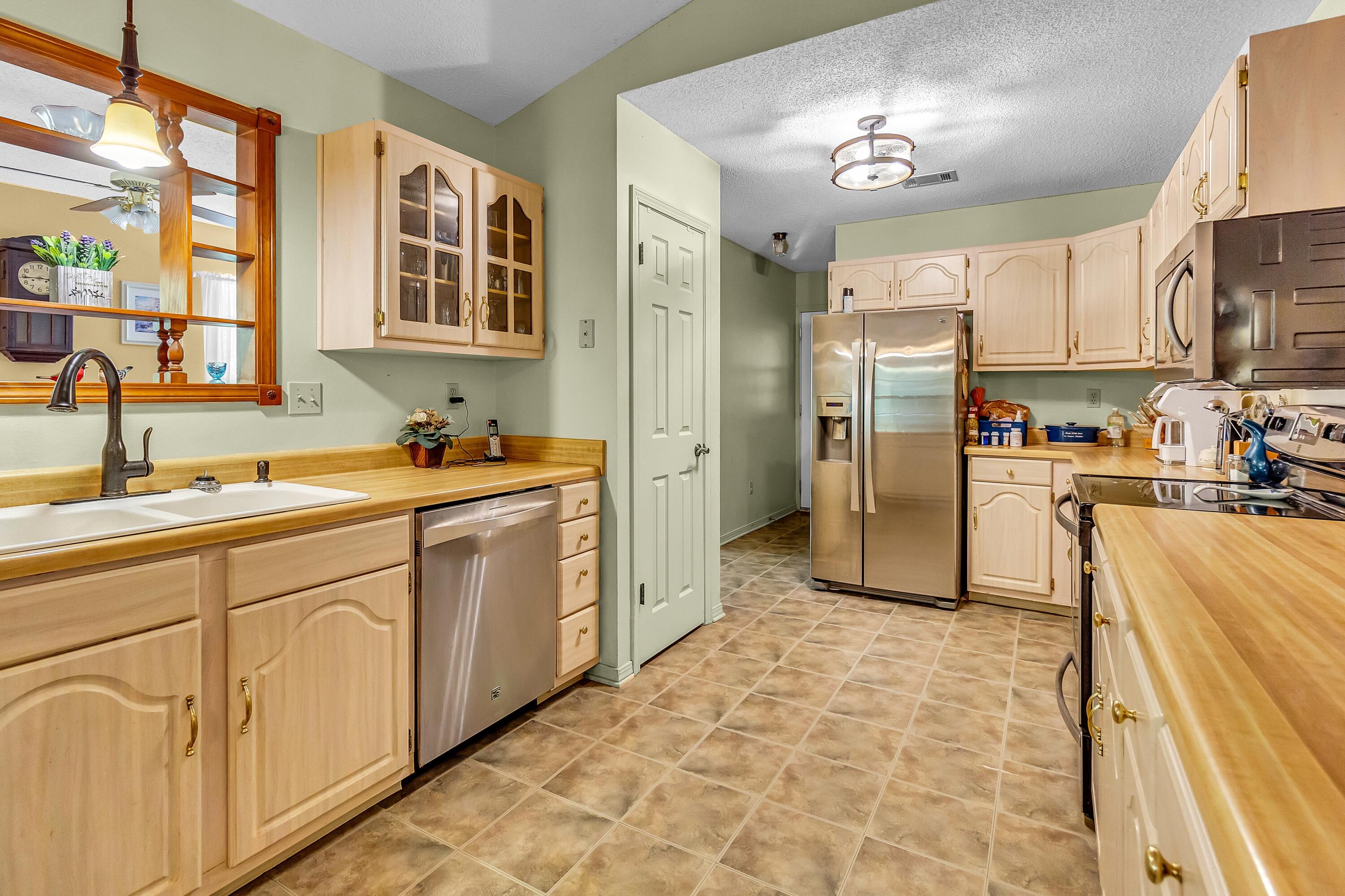 5957 Ridgecrest Road Crestview, FL 32539 - Photo 25 of 56 a kitchen with stainless steel appliances a refrigerator sink and cabinets
