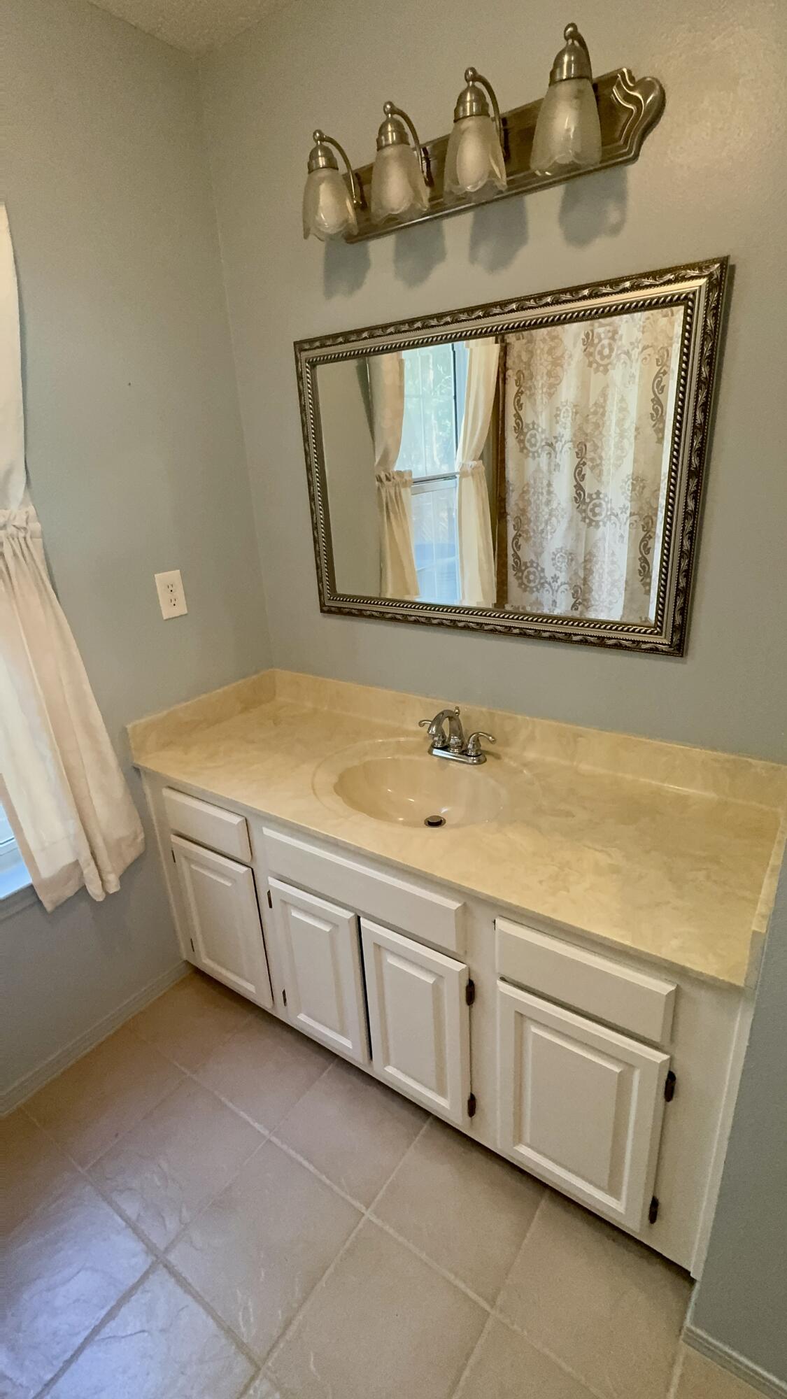 5957 Ridgecrest Road Crestview, FL 32539 - Photo 31 of 56 a bathroom with a sink and a mirror