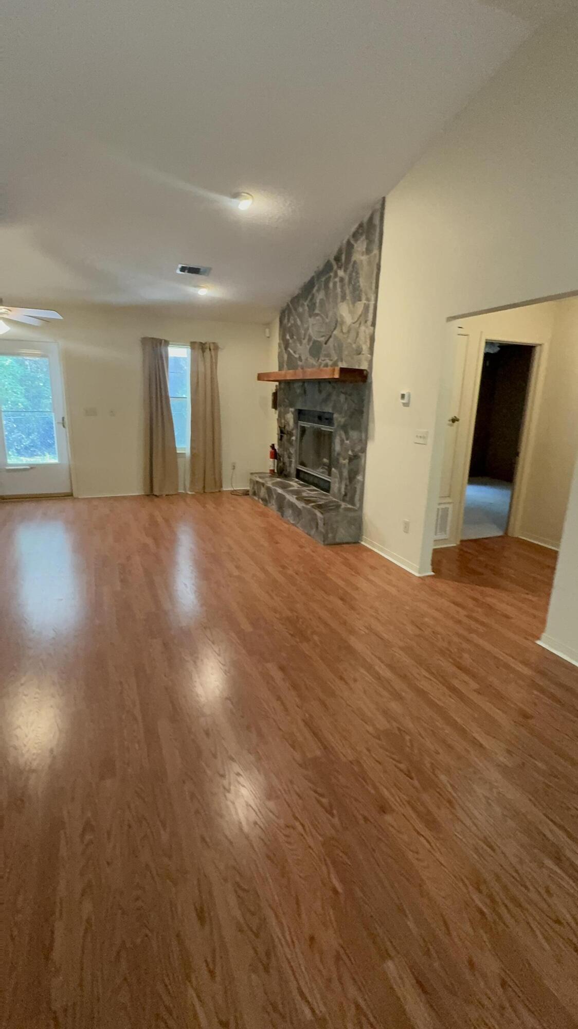 5957 Ridgecrest Road Crestview, FL 32539 - Photo 9 of 56 a view of empty room with wooden floor and fireplace