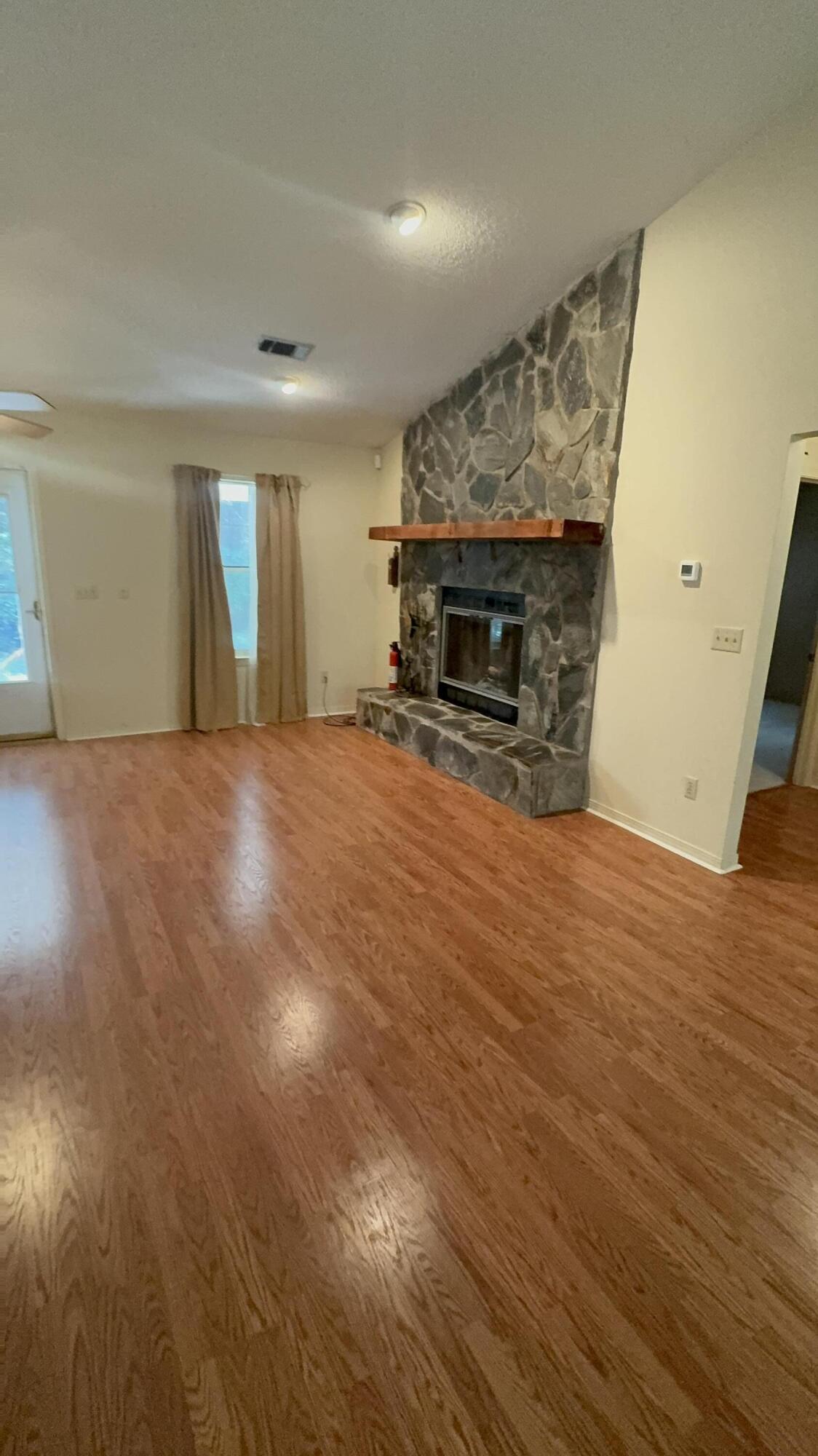 5957 Ridgecrest Road Crestview, FL 32539 - Photo 10 of 56 an empty room with wooden floor and fireplace