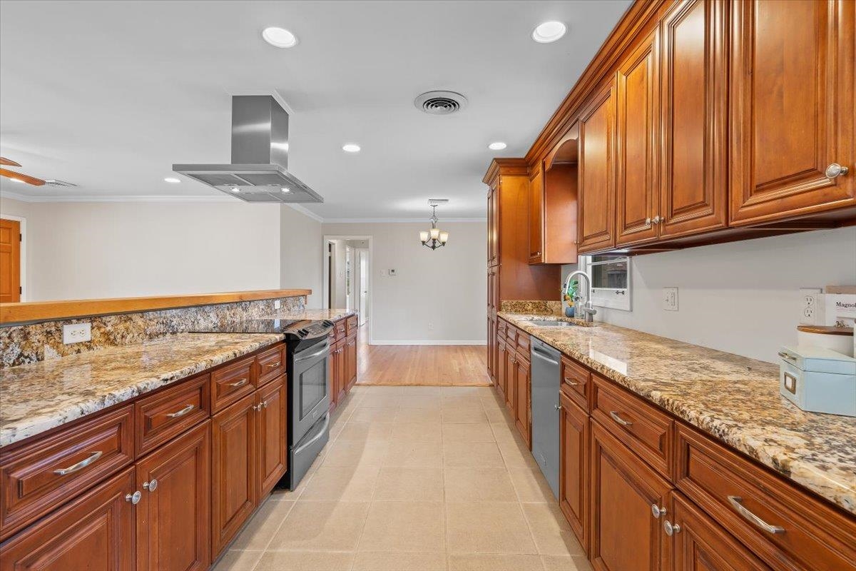 1556 Hayne Road Memphis, TN 38119 - Photo 12 of 27 a large kitchen with kitchen island granite countertop wooden cabinets a sink and dishwasher