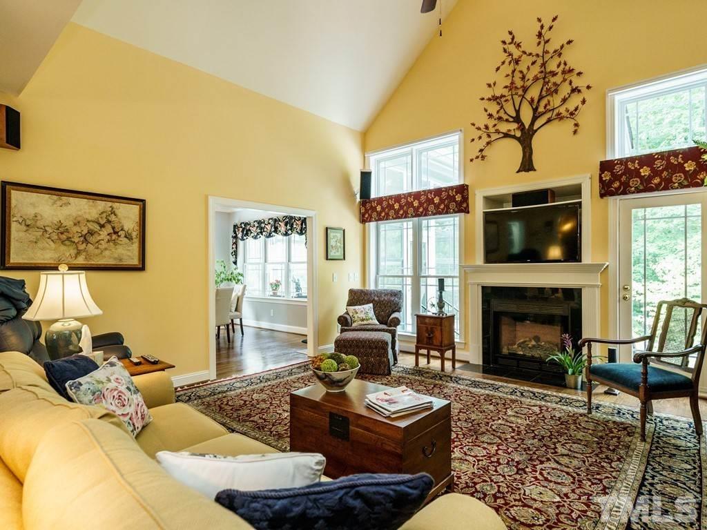 8119 Dreamy Way Raleigh, NC 27613 - Photo 14 of 30 a living room with furniture a fireplace and a potted plant