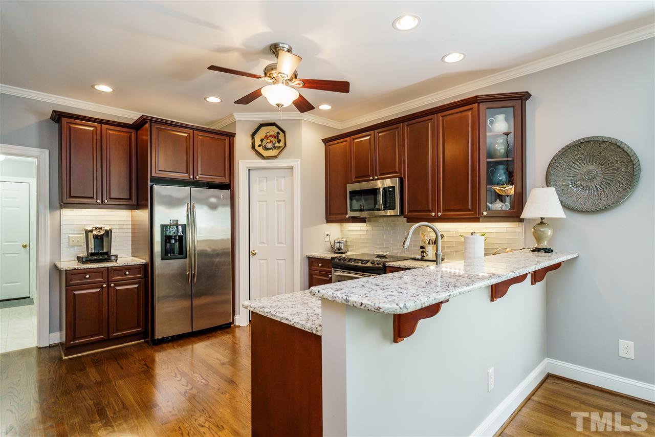 8119 Dreamy Way Raleigh, NC 27613 - Photo 6 of 30 a kitchen with kitchen island granite countertop stainless steel appliances cabinets a sink and a counter top space