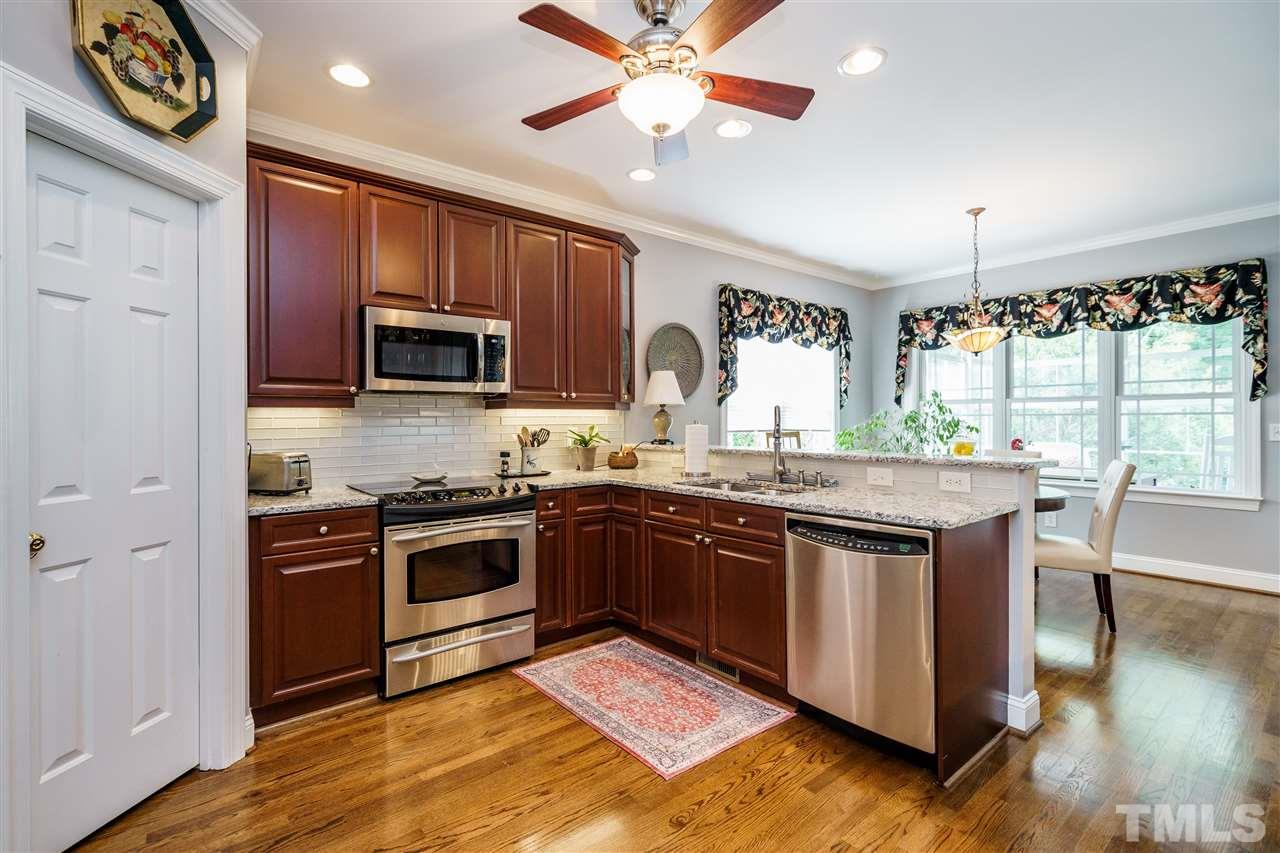 8119 Dreamy Way Raleigh, NC 27613 - Photo 7 of 30 a kitchen with granite countertop stainless steel appliances and wooden cabinets