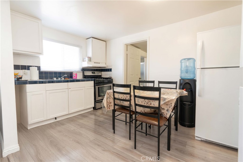 285 West 9th Street San Pedro, CA 90731 - Photo 16 of 22 a kitchen with a table chairs refrigerator and cabinets