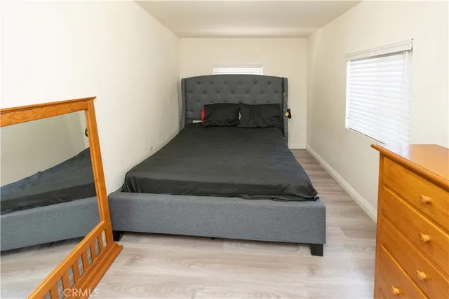 a bedroom with bed and wooden floor