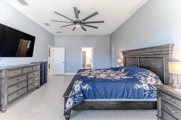a bedroom with a bed a chandelier and a television
