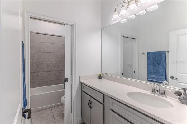 a bathroom with a sink a vanity a mirror and a bathtub