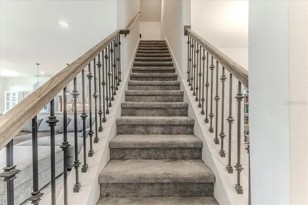 a view of staircase with wooden floor and white walls