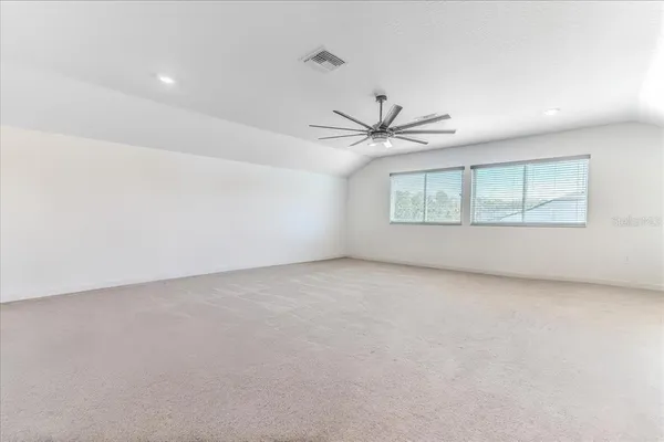 an empty room with a window and a ceiling fan