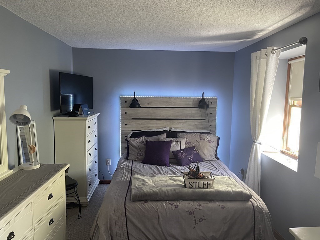178 3rd Street, Unit 178 Lowell, MA 01850 - Photo 11 of 18 a bedroom with a bed and flat tv screen