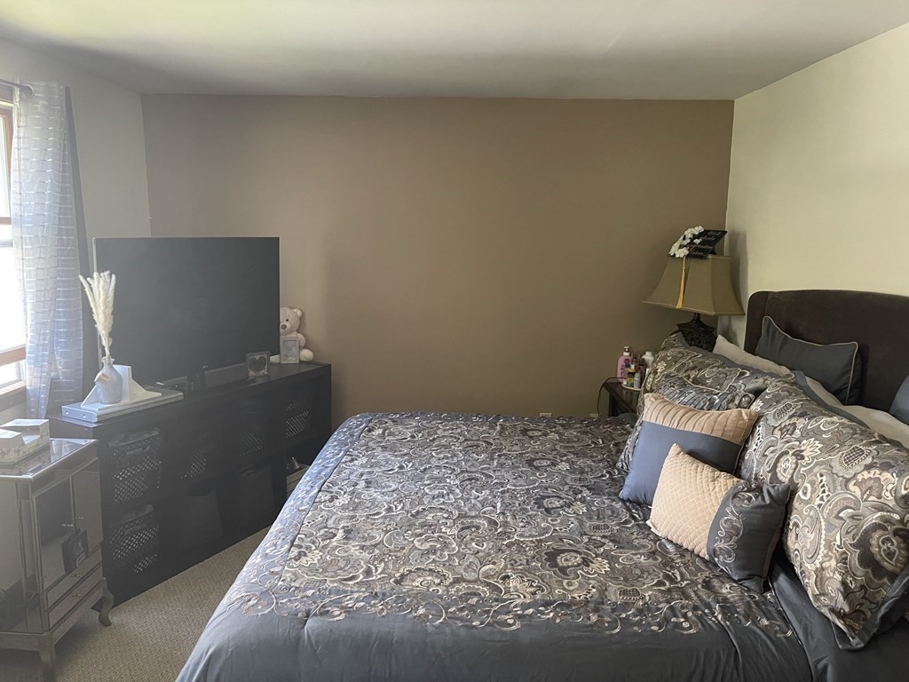 178 3rd Street, Unit 178 Lowell, MA 01850 - Photo 16 of 18 a bedroom with a bed and chair