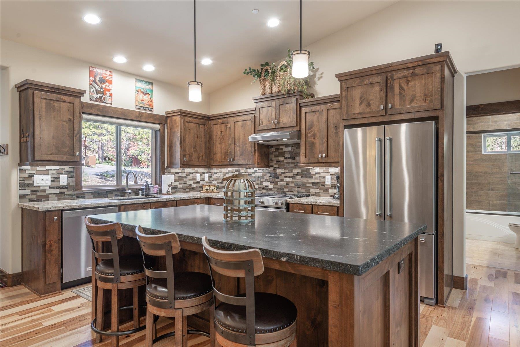 14475 Alder Creek Road Truckee, CA 96161 - Photo 7 of 21 a kitchen with granite countertop a table chairs stove refrigerator and cabinets