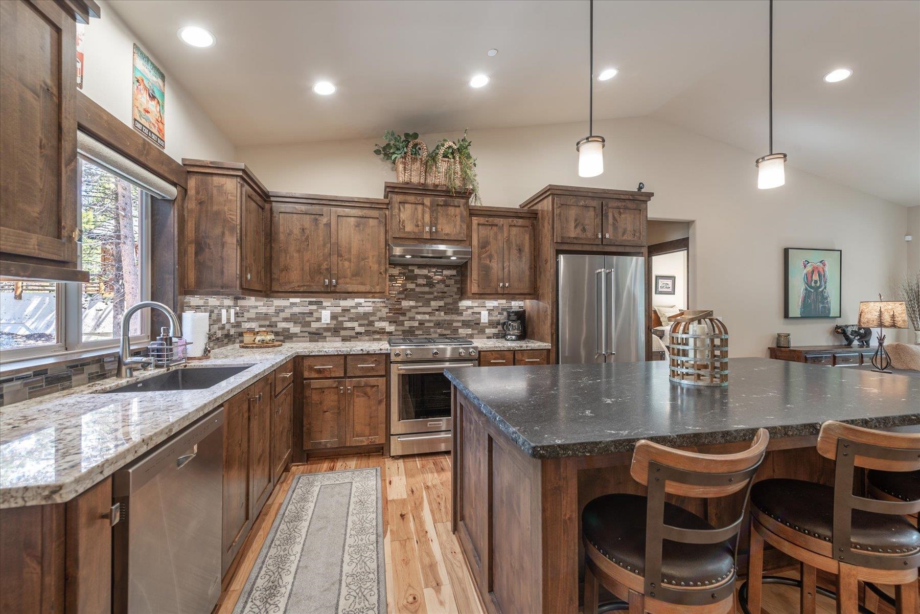 14475 Alder Creek Road Truckee, CA 96161 - Photo 8 of 21 a kitchen with kitchen island granite countertop lots of wooden cabinets a sink stainless steel appliances and dining table