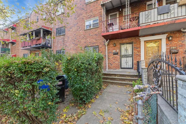 a view of a house with a large windows and flower plants