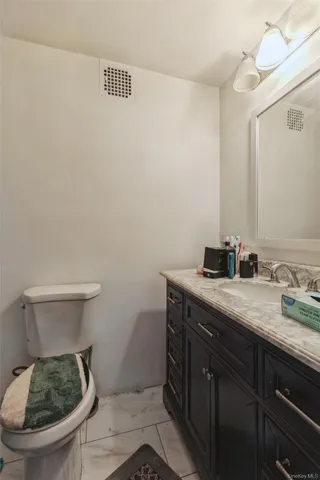 a bathroom with a toilet a sink and mirror