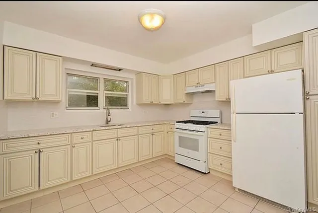 a kitchen with white cabinets and white appliances