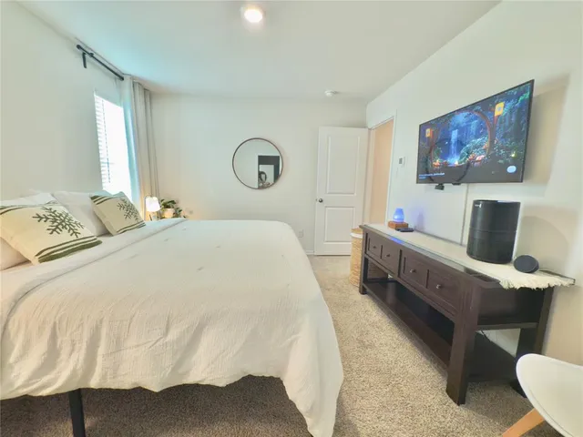 a bedroom with a bed and a flat screen tv