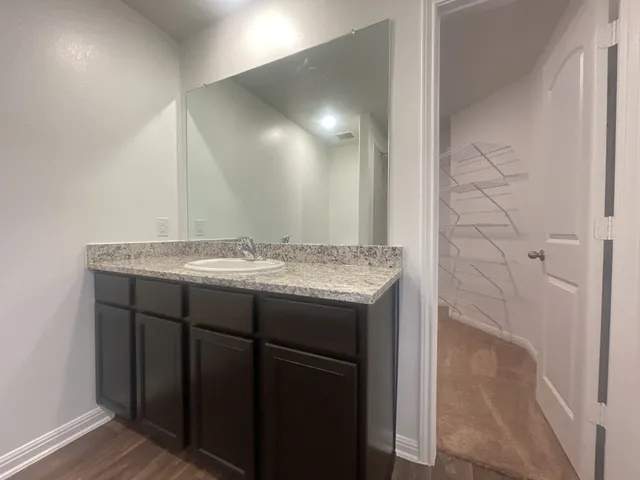 a bathroom with a granite countertop sink and a mirror