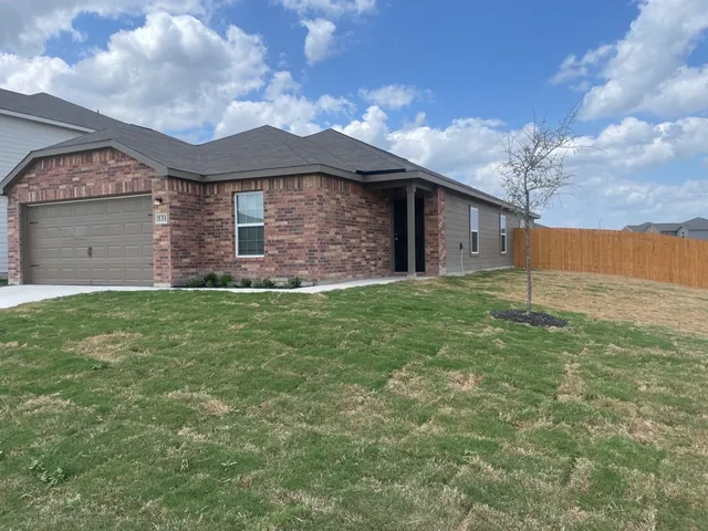 a front view of house with yard and garage