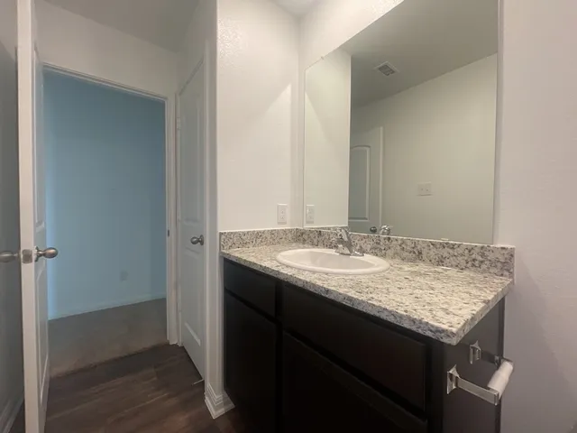 a bathroom with a granite countertop sink and a mirror