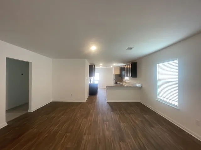 a view of a big room with wooden floor and windows