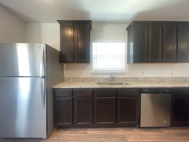 a kitchen with a sink cabinets and a refrigerator
