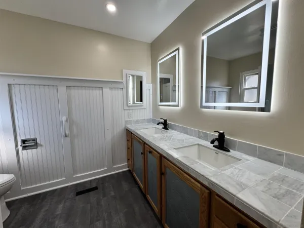 a bathroom with a granite countertop sink and a mirror