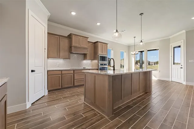 a kitchen with kitchen island white cabinets stainless steel appliances a sink and living room view