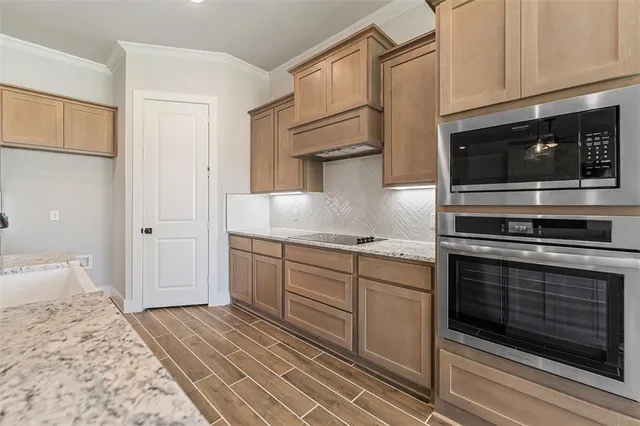 a kitchen with granite countertop cabinets stainless steel appliances and a counter space