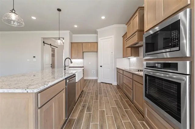 a kitchen with stainless steel appliances granite countertop a stove a sink and a refrigerator