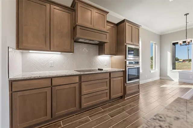 a kitchen with granite countertop white cabinets and stainless steel appliances