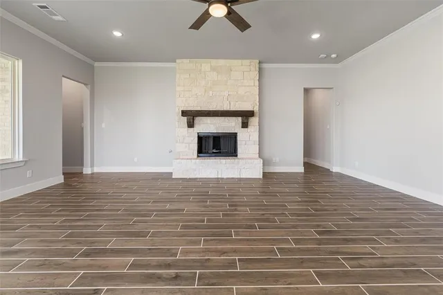 a view of empty room with wooden floor and fireplace