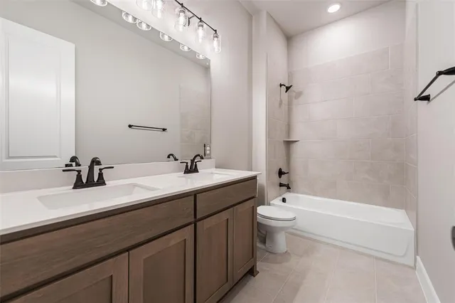 a bathroom with a double vanity sink toilet mirror and bathtub