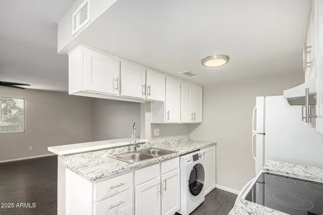 a kitchen with granite countertop a sink a stove and cabinets